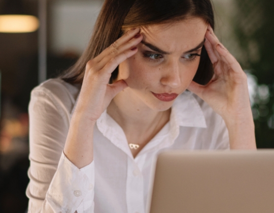 Ragazza che sta lavorando al computer con espressione stanca
